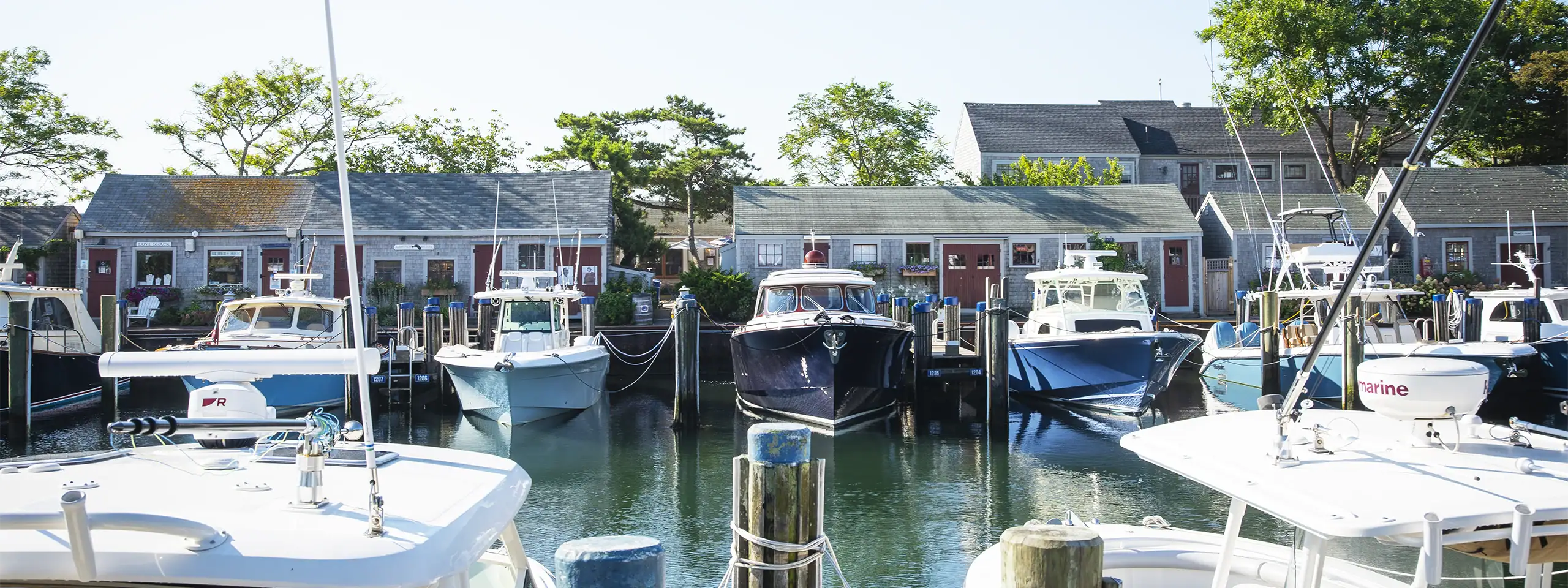 Marina with boats docked along a calm waterway in a residential area.
