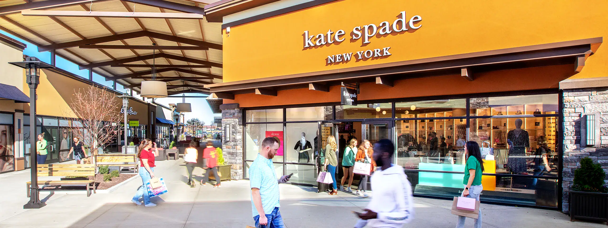 Kate Spade New York store exterior with shoppers outside.