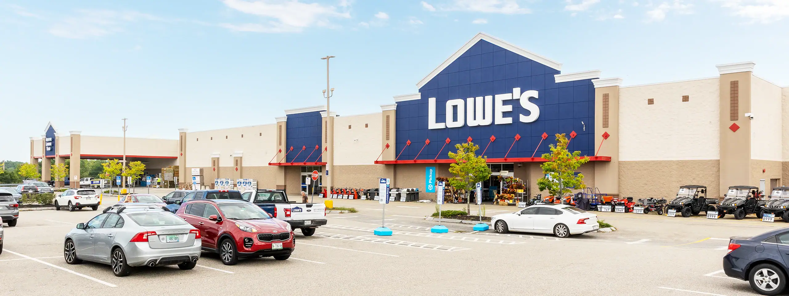 Lowe's store with parking lot and cars in front, clear sky, daytime.