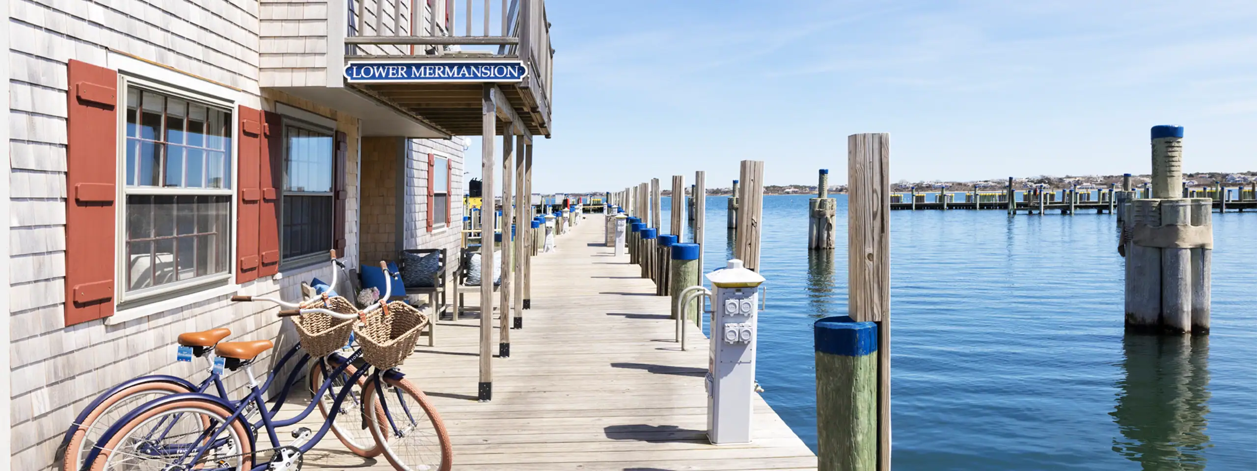 View of a waterfront dock with boats and a building with a balcony.
