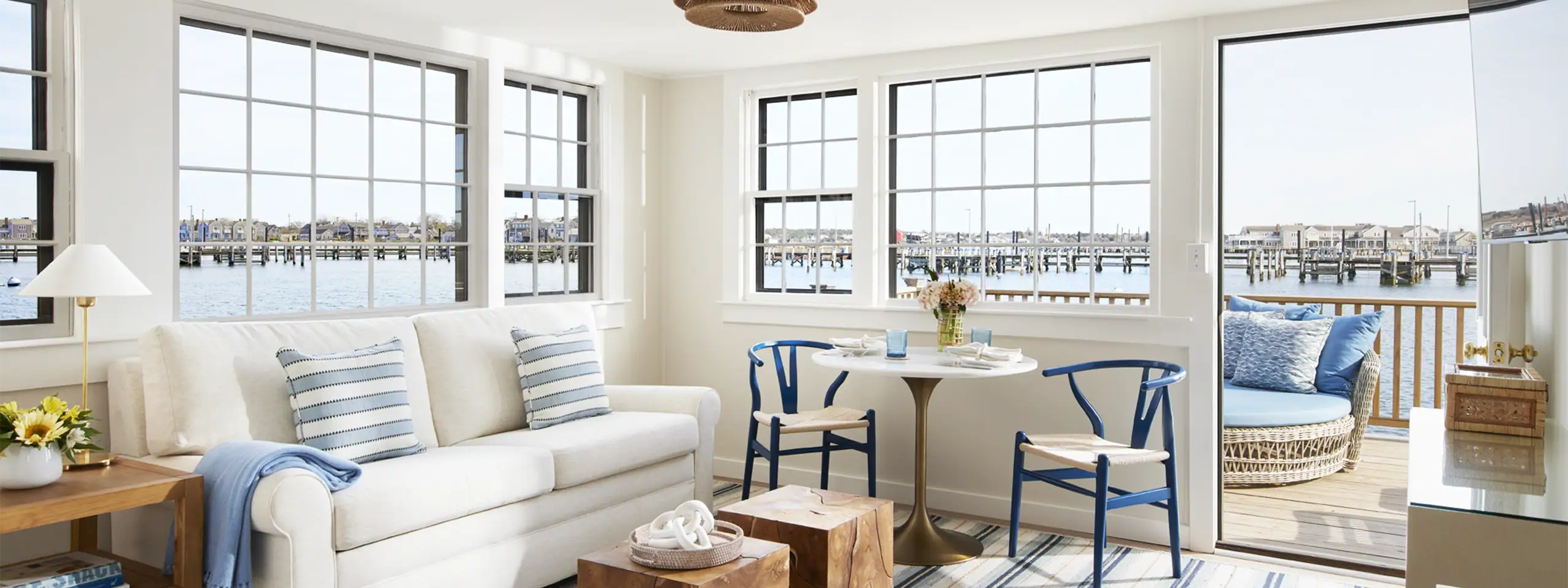 Bright living room with large windows overlooking a waterfront view.
