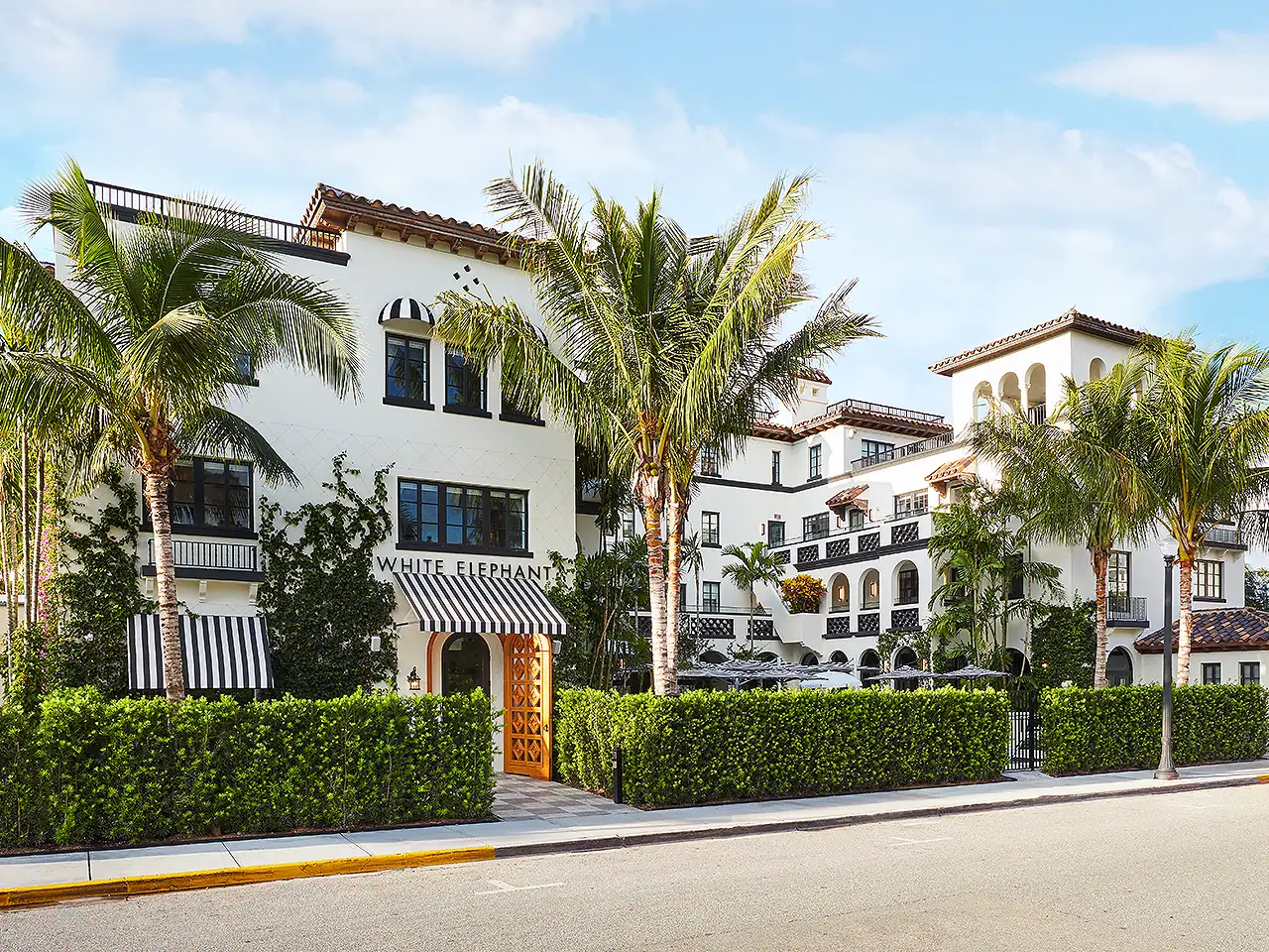 White Elephant hotel with palm trees and lush greenery in Miami Beach, Florida.