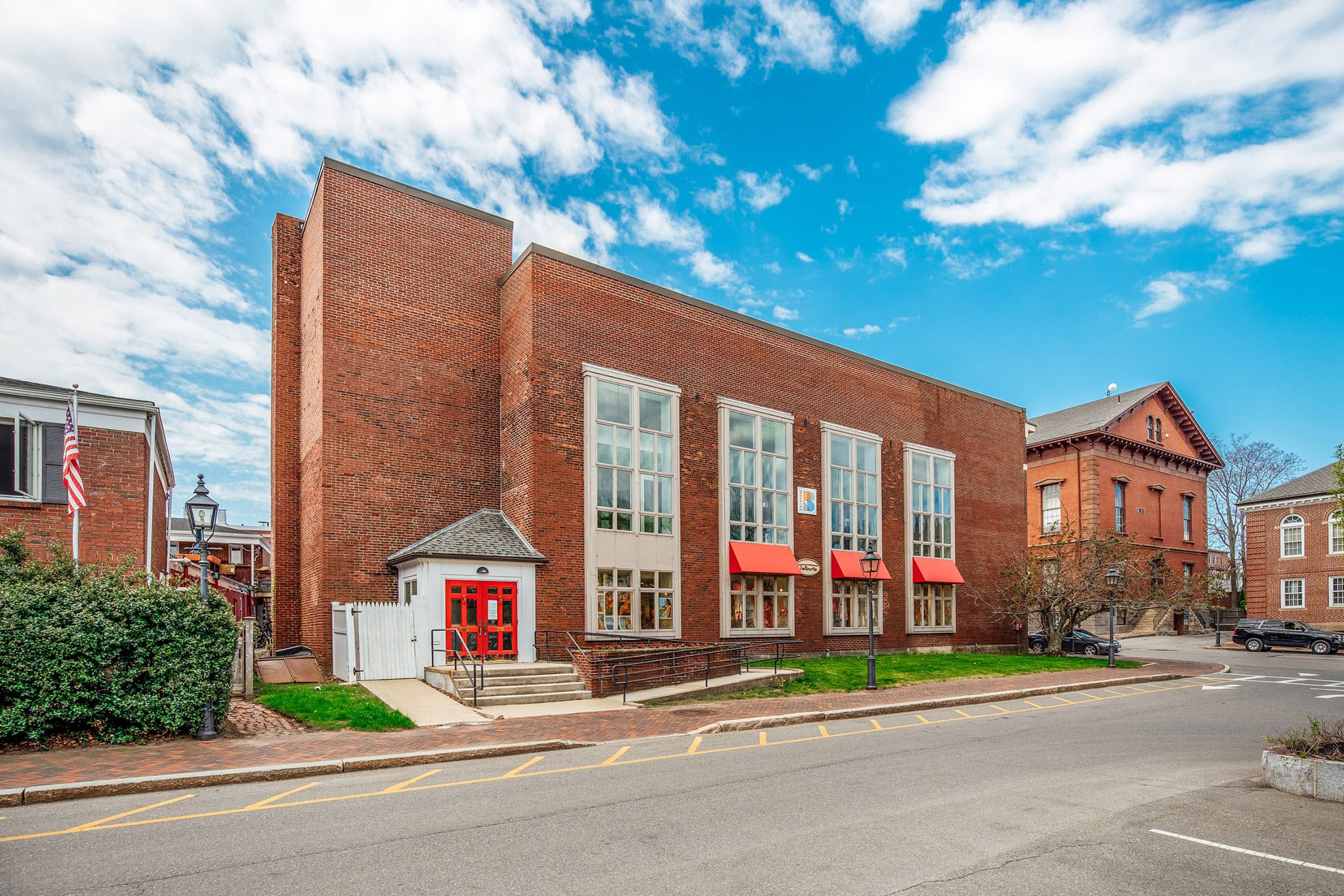 Modern brick building with large windows and red awnings in Newburyport.