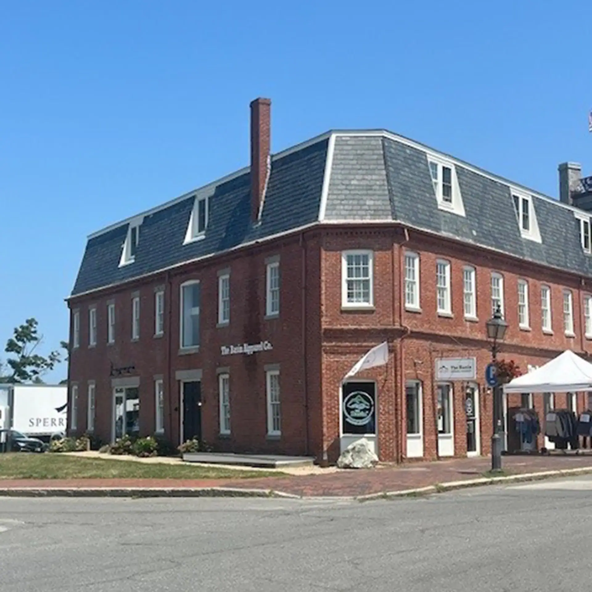 Historic brick building on a street corner with a blue sky background.