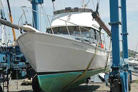 White motorboat on a boat lift at a marina with blue supports.