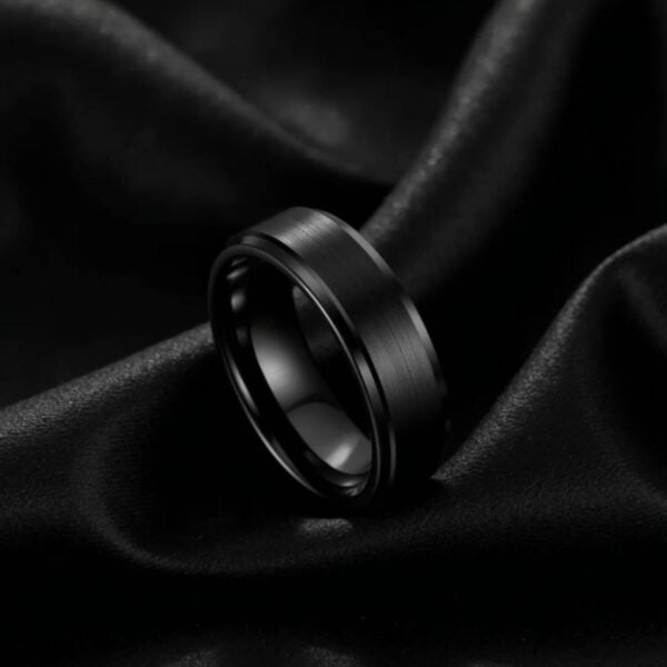 An all black mans wedding band or engagement ring. Made with tungsten, providing an ultra strong and long lasting ring for him
