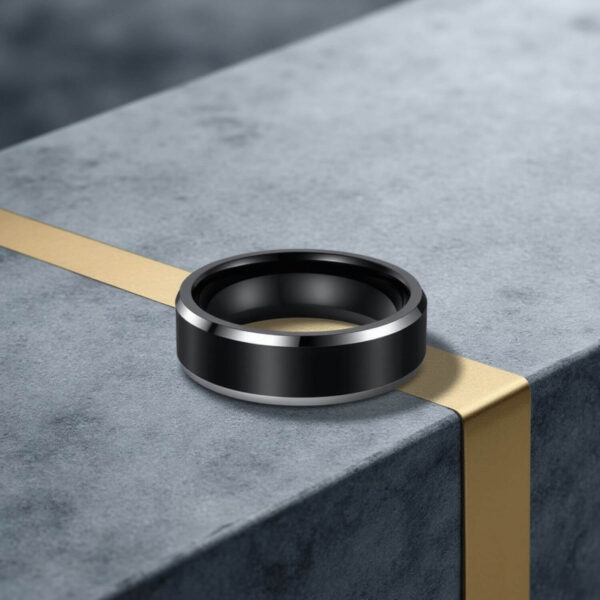 A black titanium ring for men featuring polished silver bevelled edges for added style. This elegant ring is perfect as a mans wedding ring or engagement ring for him.