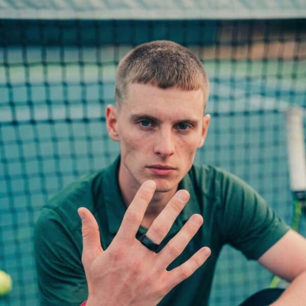 Pausing play at the tennis match, the tennis player holds up his hand to show his black tungsten ring. Slightly domed, it is perfect as a mans wedding band.