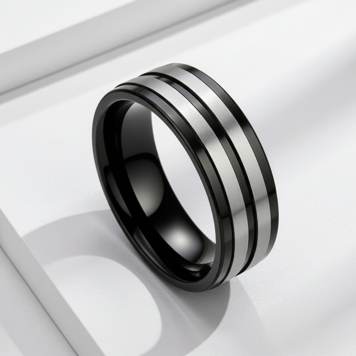 Black and silver men’s titanium wedding band with bold contrast and clean modern styling.