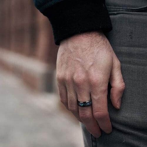 Man wearing black titanium and abalone shell ring