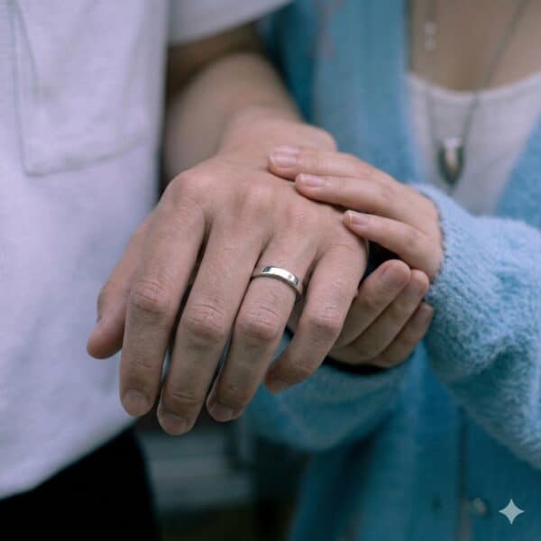 An elegant white gold ring that is slim in style. This 4mm ring is being shown as a close up on a mans hand to show his engagement ring.