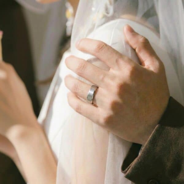 The newly wed couple pose for a photo, the man wearing a white gold tungsten ring.