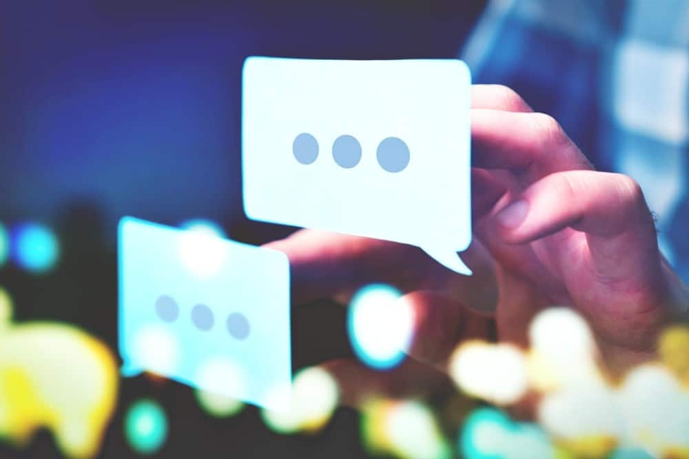 Communication, dialog, conversation on an online forum and internet chatting concept. Business man or social media consultant holding speech bubbles in futuristic modern abstract space. Communication dialog conversation on an online forum and internet chatting concept