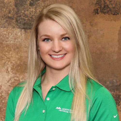 Young woman in green North Platte Physical Therapy shirt smiling.