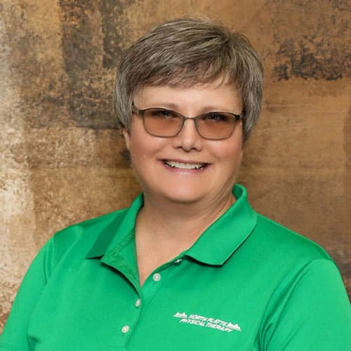 North Platte Physical Therapy staff member in green polo shirt with logo.
