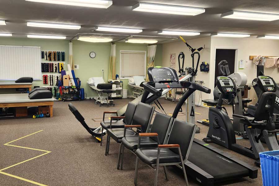 Therapy gym with exercise equipment and chairs at North Platte PT.