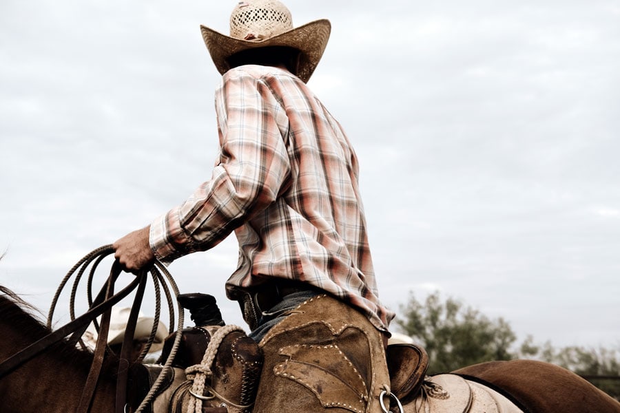 Cowboy riding horse outdoors, representing physical activity and rehabilitation.