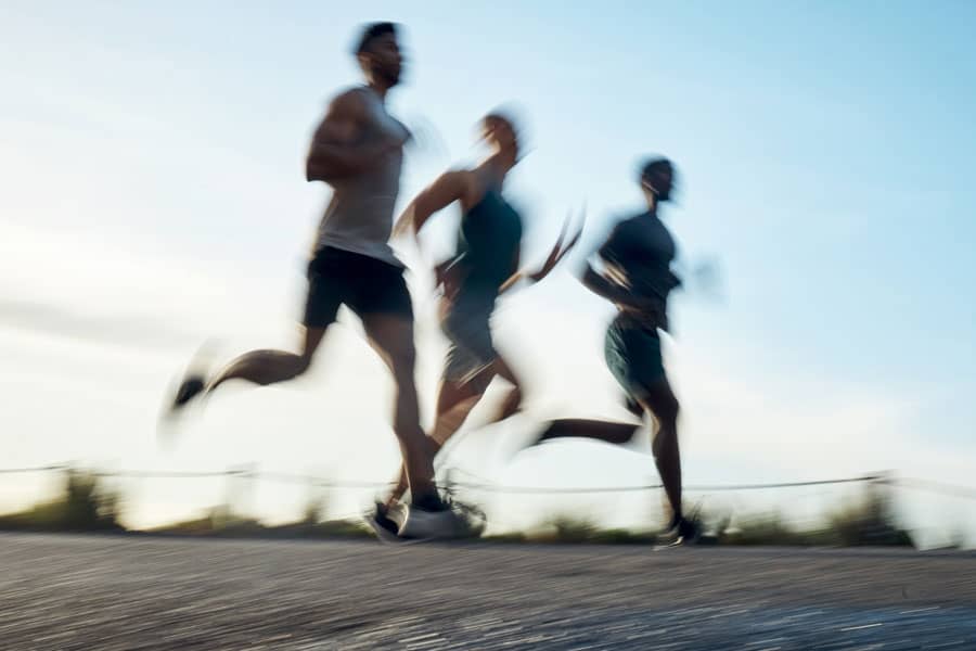 Group of runners training outdoors, focus on injury prevention and recovery.