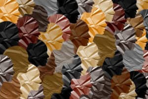 A pattern of overlapping human profiles in various skin tones, all with a crumpled, textured appearance, symbolizing diversity and unity—perfect for celebrating Black History Month.