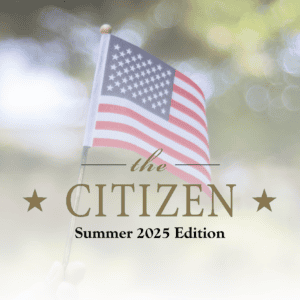 A hand holds a small American flag against a blurred outdoor background. Text overlays read: "The Citizen Summer 2025 Edition," with stars on either side of "Citizen," celebrating community spirit.