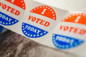 Roll of "I voted" circular stickers on a gray background for the November elections in the United States.
