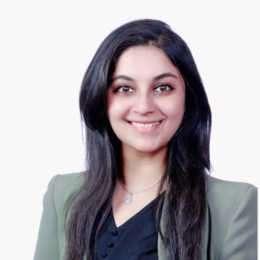Woman smiling in professional attire, representing medical professional or researcher in oncology field.