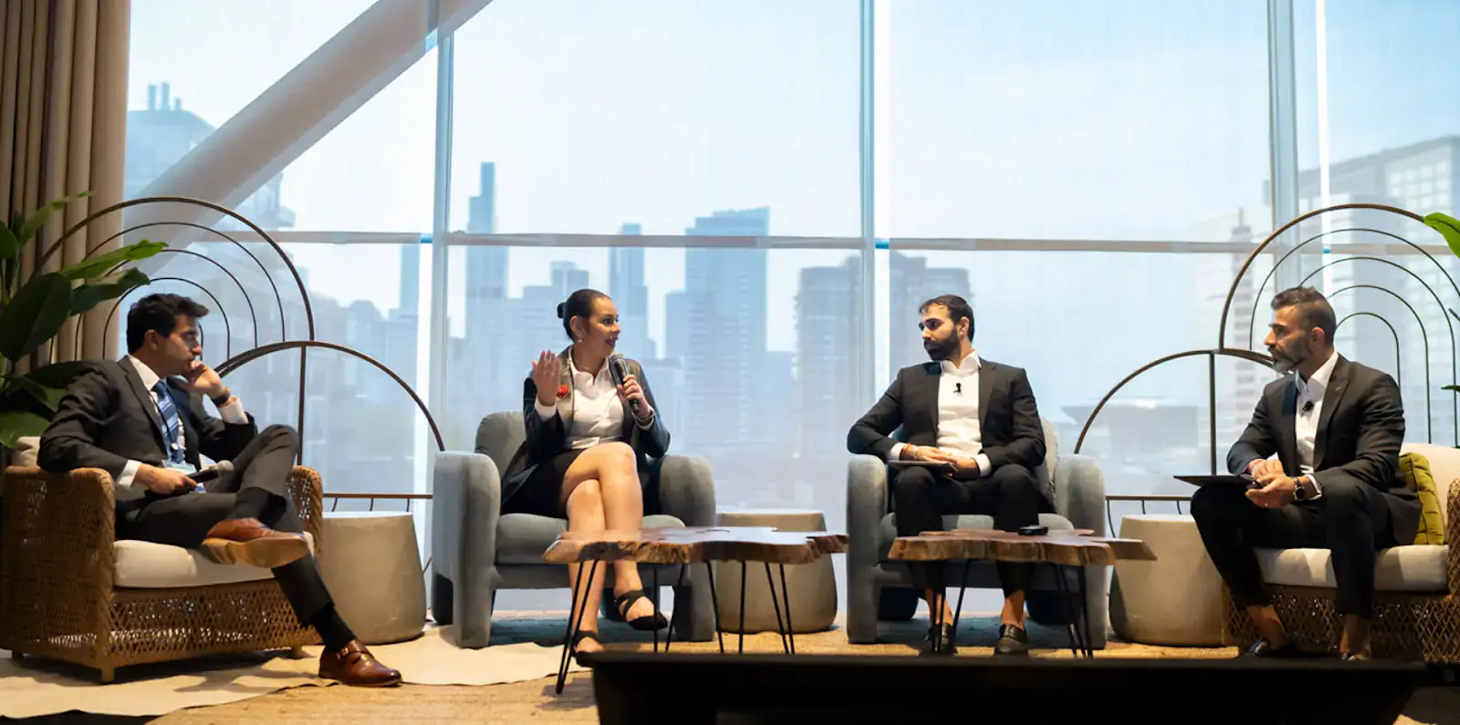 Discussion panel at a medical conference with professionals in a modern cityscape setting, focused on oncology updates and research advancements.