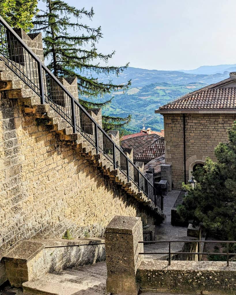 Stone steps lead upward toward the first of San Marino’s Three Towers, with sweeping views across the surrounding hills.