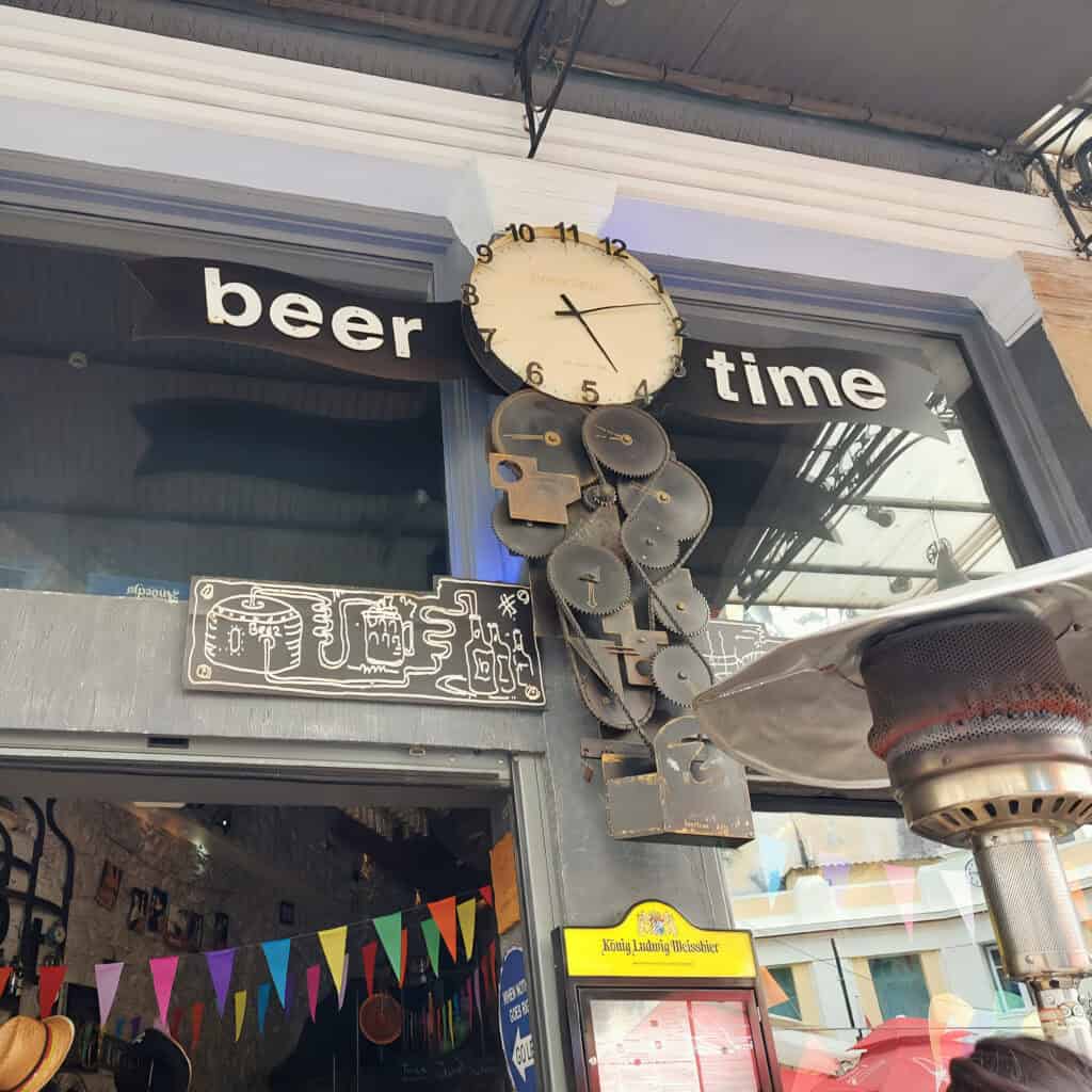 Beer Time Craft Beer Bar Athens outside with a big clock