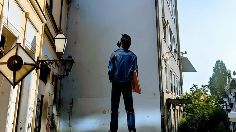 street art of a man with a red folder looking up in Samala Belgrade