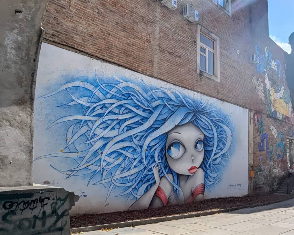 street art in Kutaisi head of lady with bkue hair