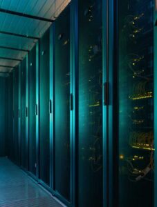 Clean data center server racks with illuminated glass doors.