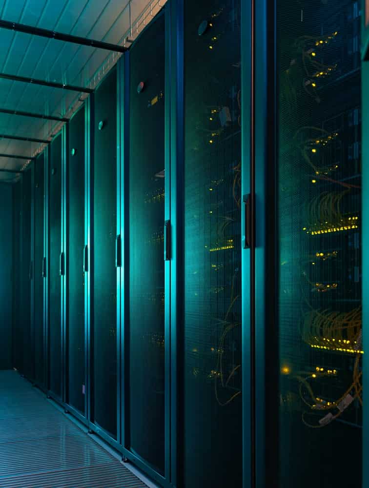 Clean data center server racks with illuminated glass doors.