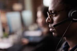 Customer service representative wearing headset and glasses at work.