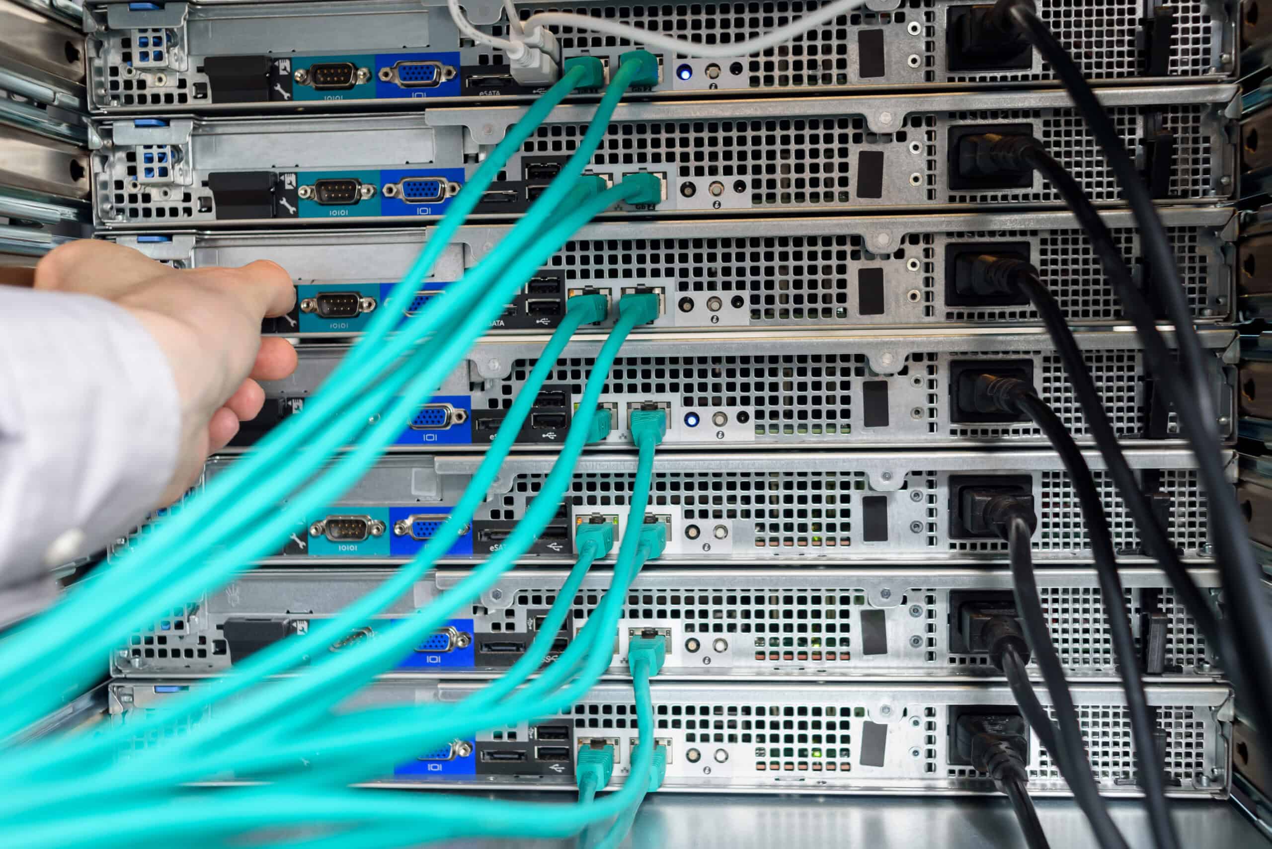 Rack-mounted servers with network cables being connected.