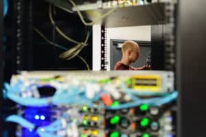 Tech worker configuring server hardware in data center.