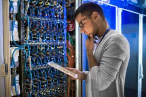 High-tech network engineer analyzing data in a server room.