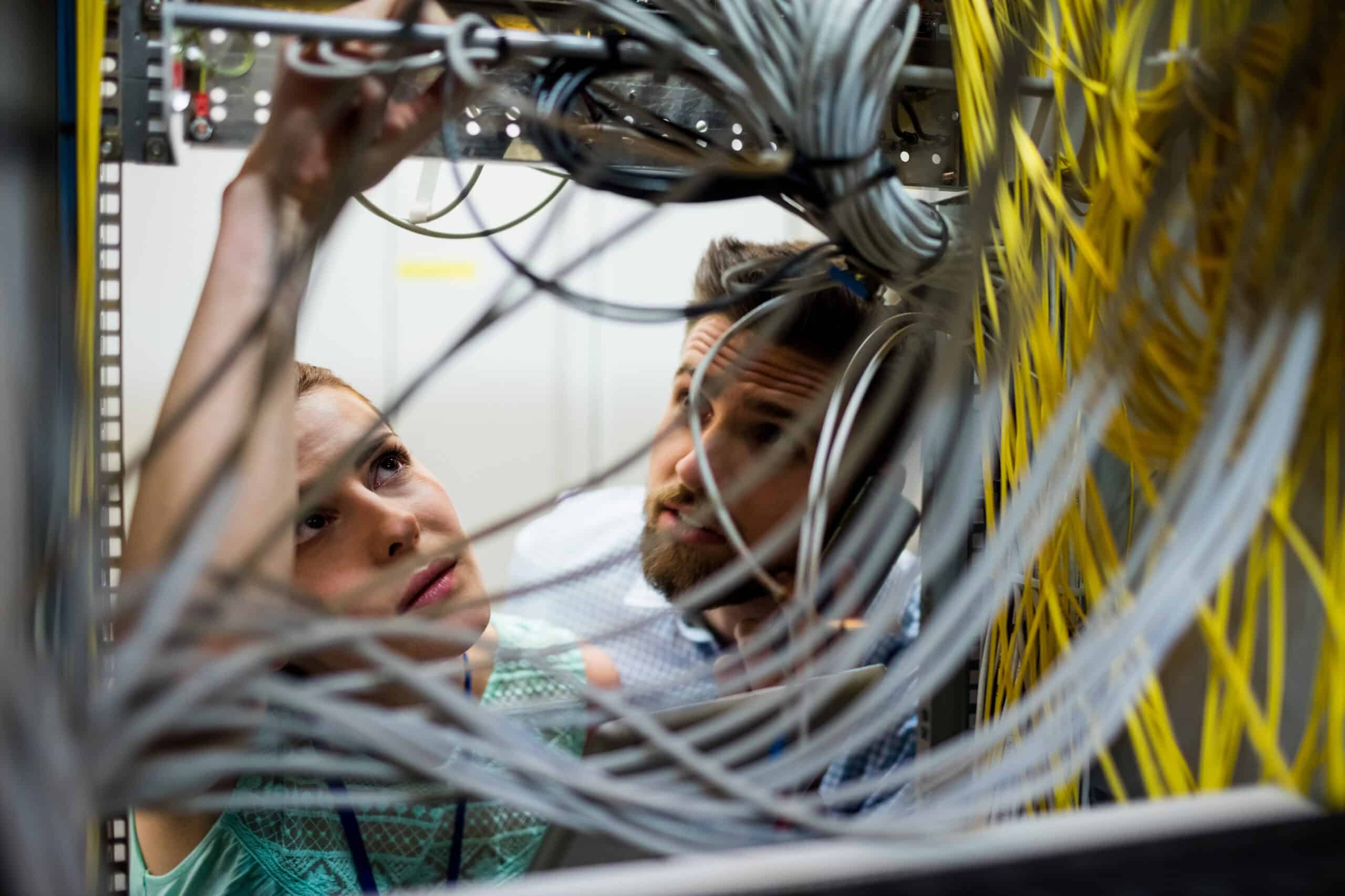 High-tech network technicians working on server wiring in a data center.