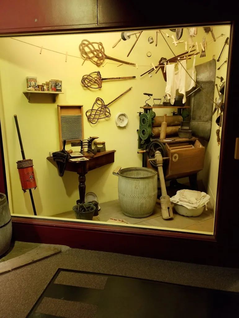 A storage room filled with vintage and antique tools, including yarn winders, wooden rolling pins, and old machinery, perfect for restoration projects or vintage collections.