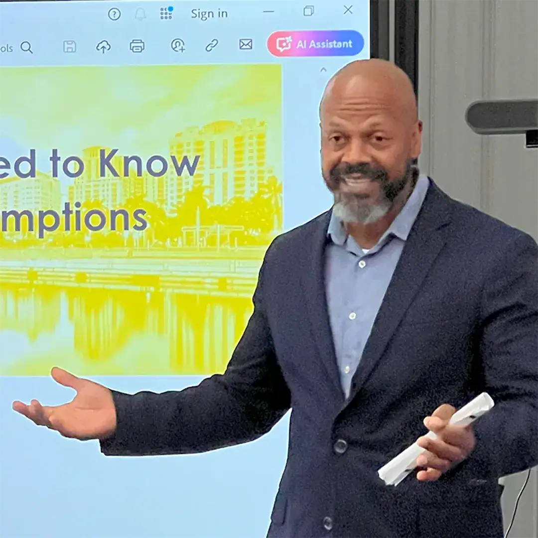 Man in a suit delivers a presentation to an audience.