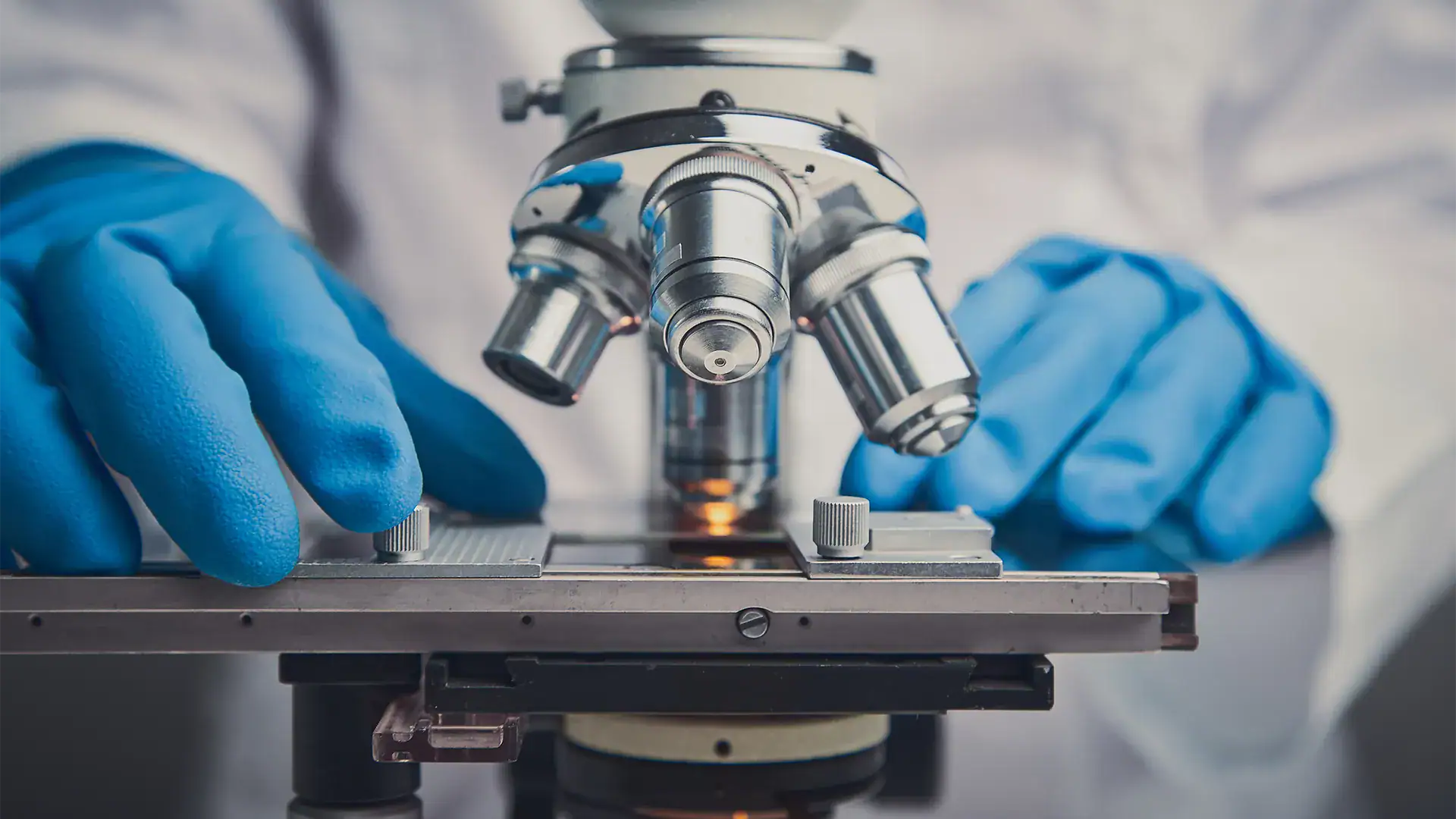 up close image of a scientist performing research using a microscope