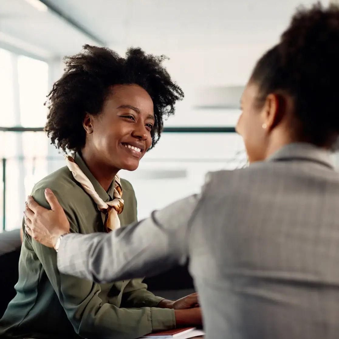 Smiling woman and man engaging in a warm conversation at work.
