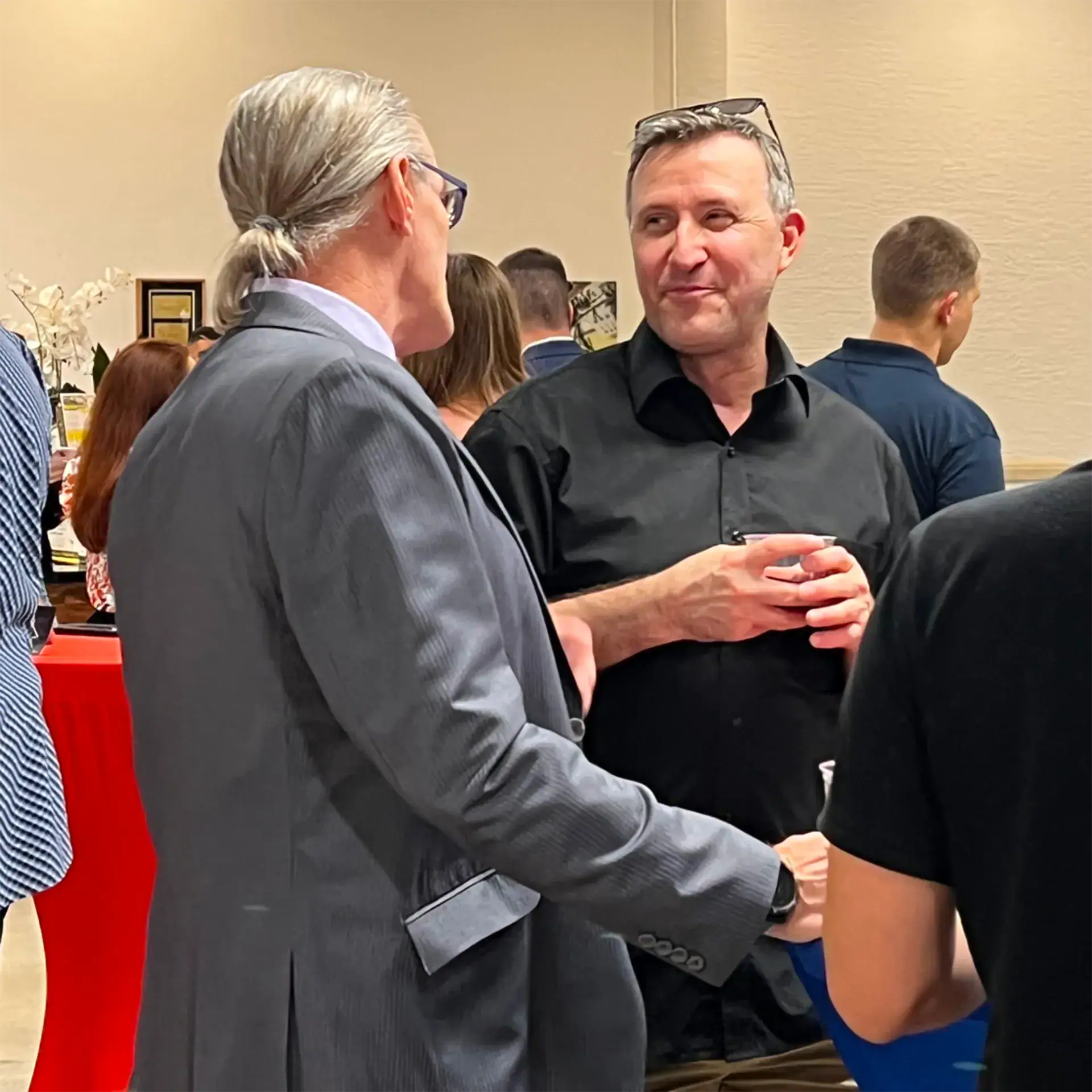 Networking professionals engaging in conversation at a conference or event.
