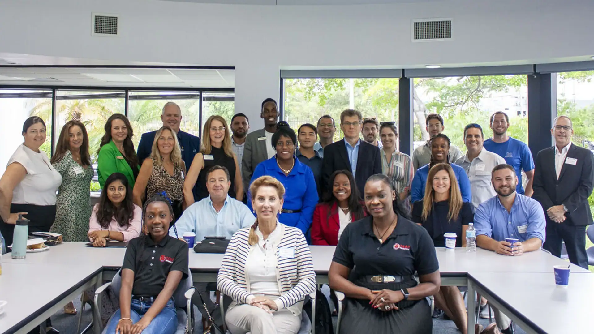 People smiling and posing together in a bright, spacious office setting.