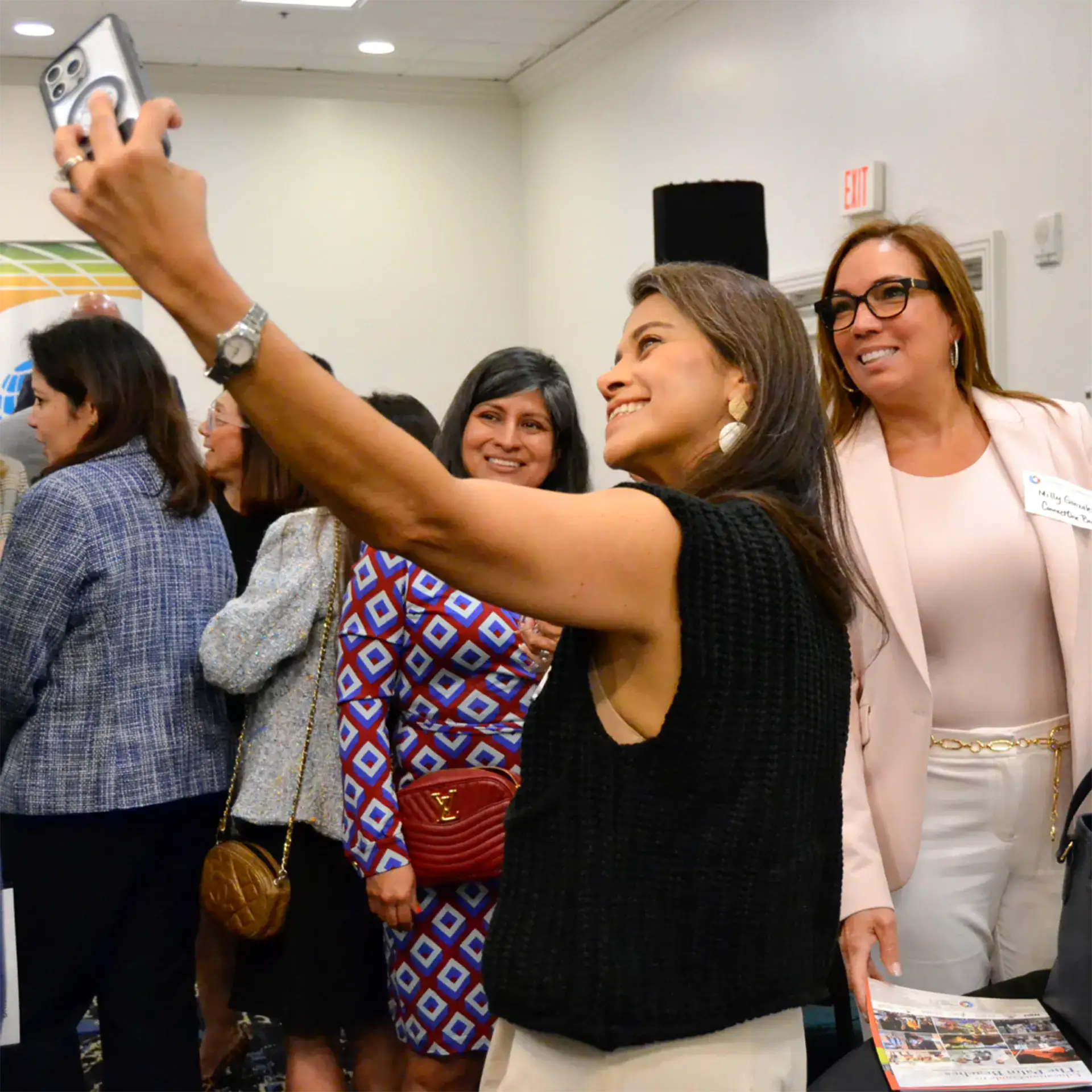 Women taking a selfie at a professional event.