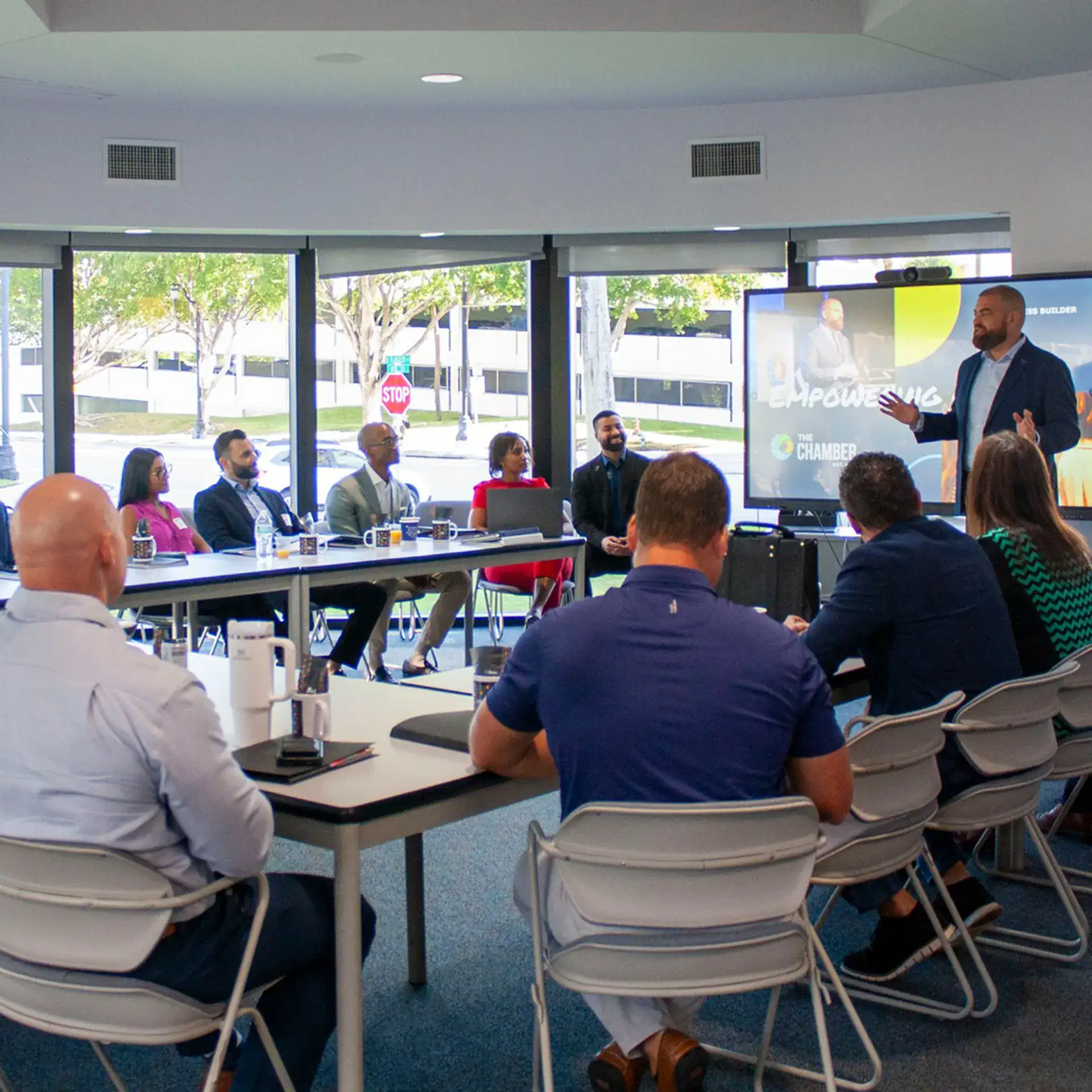 A man in a suit is speaking to an audience during a professional seminar.