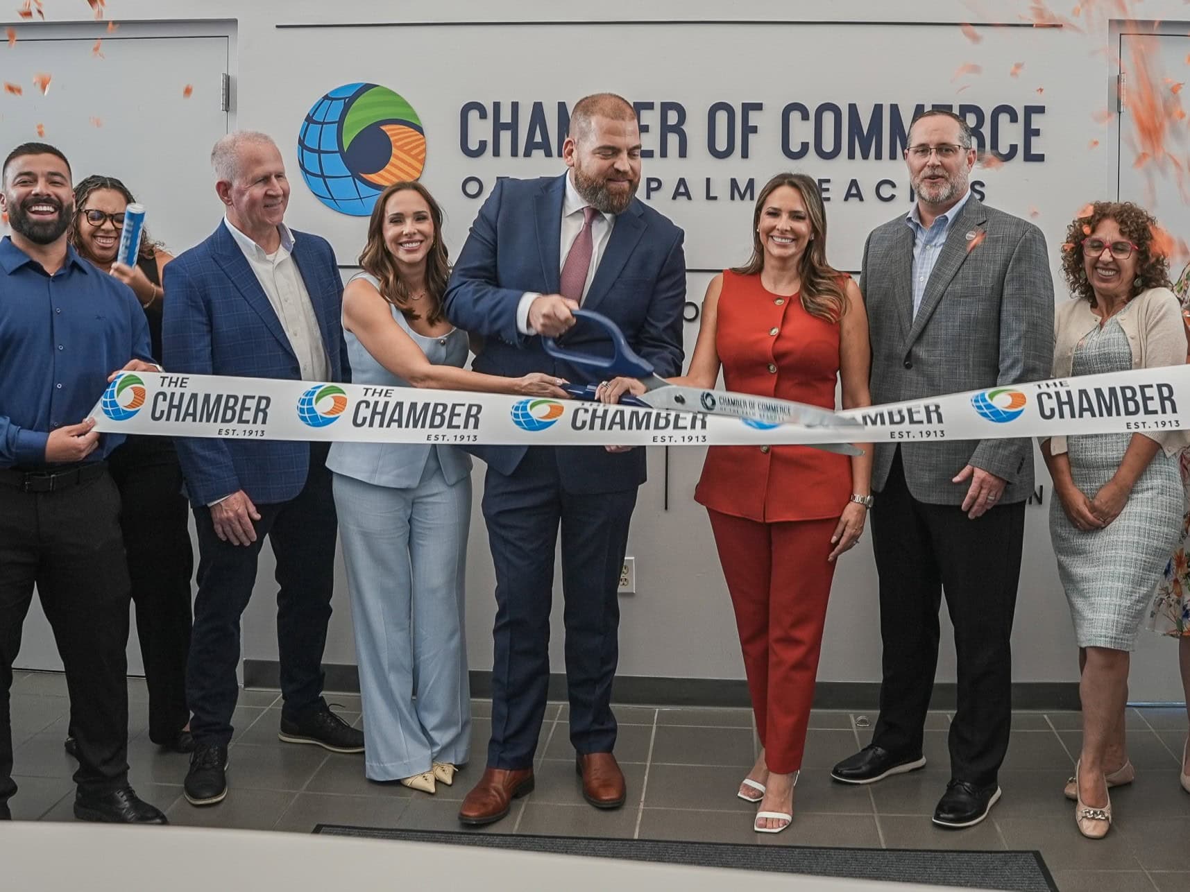 People gathered for ribbon-cutting event celebrating new business opportunities.