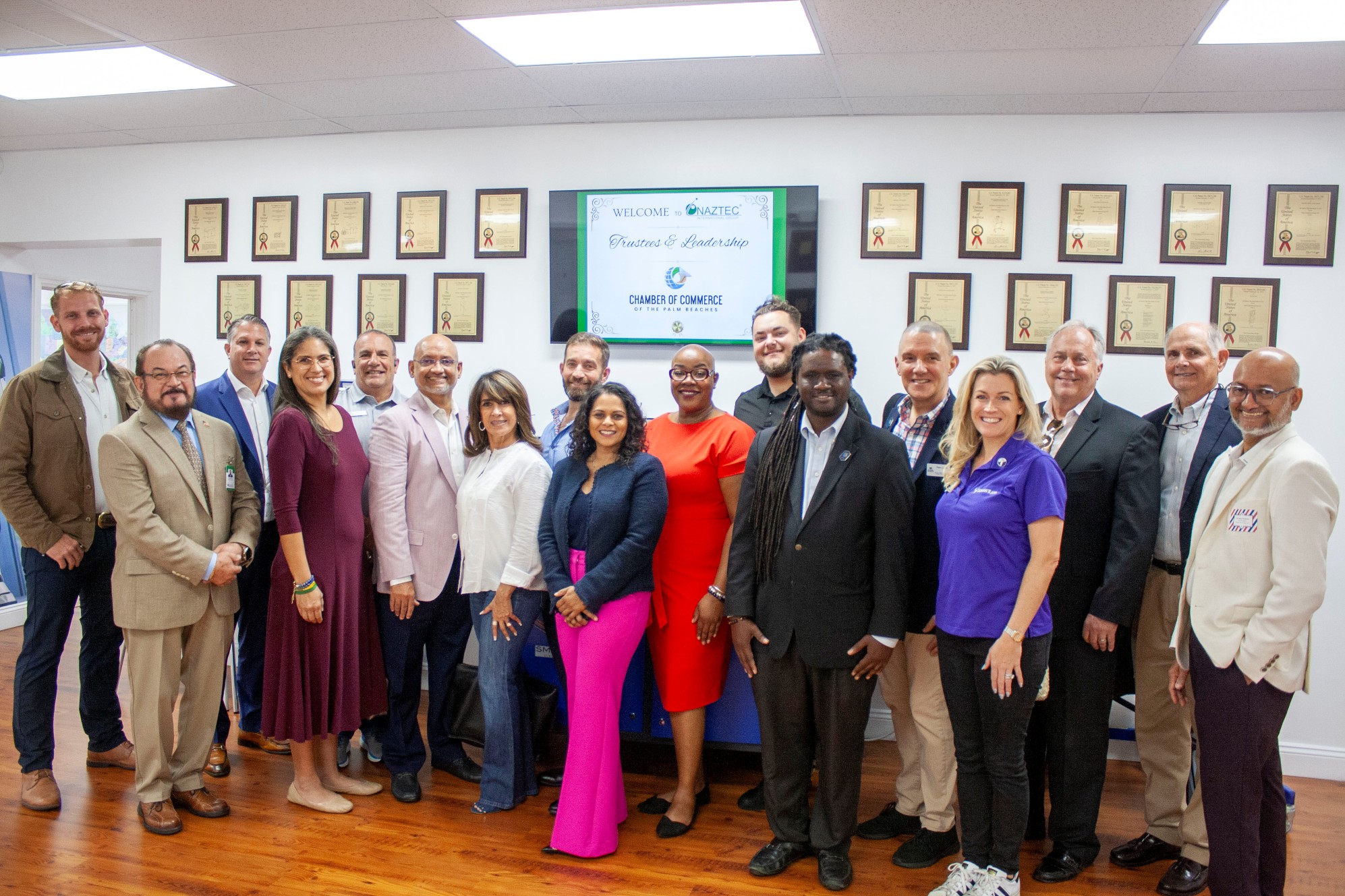 Diverse group of people posing for a photo at a professional event.