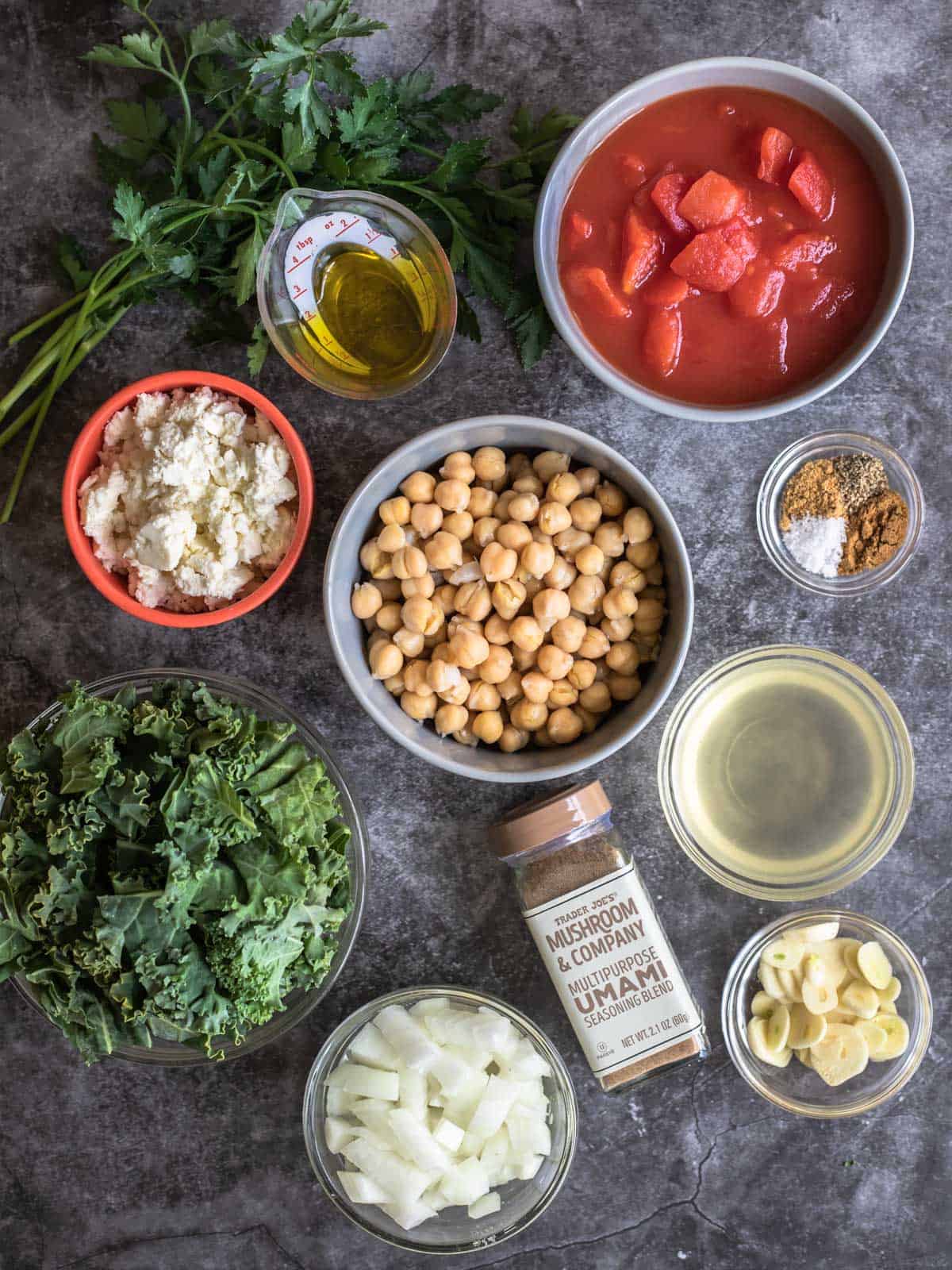 ingredients for this recipe: canned tomatoes, canned chickpeas, olive oil, kale, onion, garlic, broth, umami seasoning, ground coriander and cumin