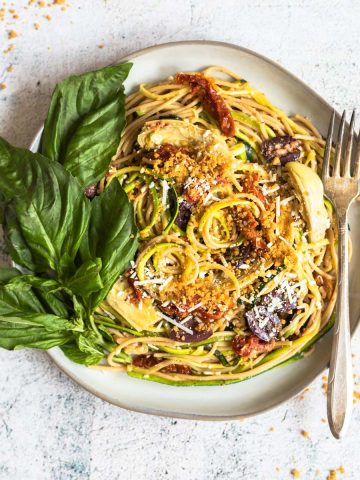 Mediterranean zucchini spaghetti on a plate with a fork